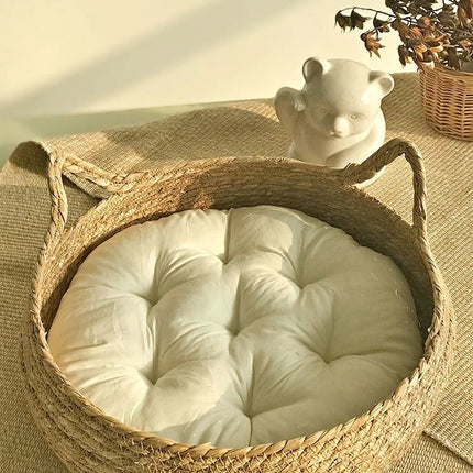 Panier rond tressé avec coussin blanc cassé et détails décoratifs